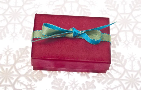 Festive Holiday Gift Box on a Snow Flake Background — Stock Photo, Image