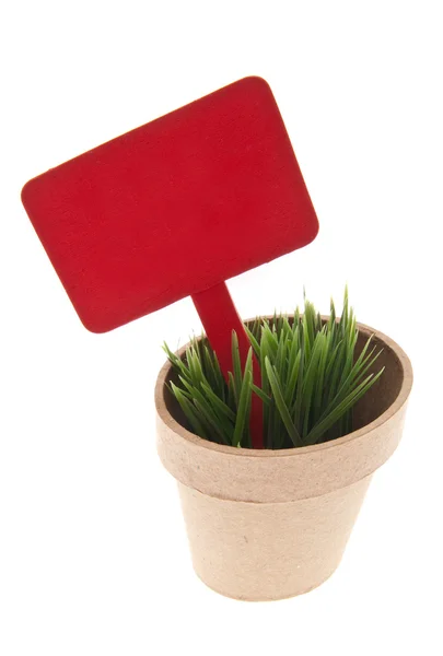 Pot of Grass with Vibrant Red Sign — Stock Photo, Image