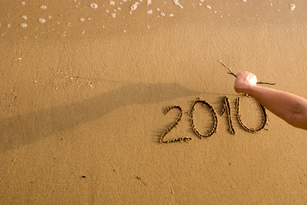 Año 2010 escrito en la arena — Foto de Stock