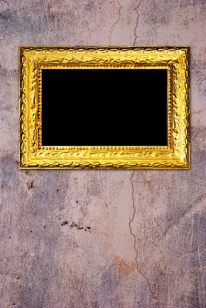 Moldura de ouro em um fundo de parede velha — Fotografia de Stock