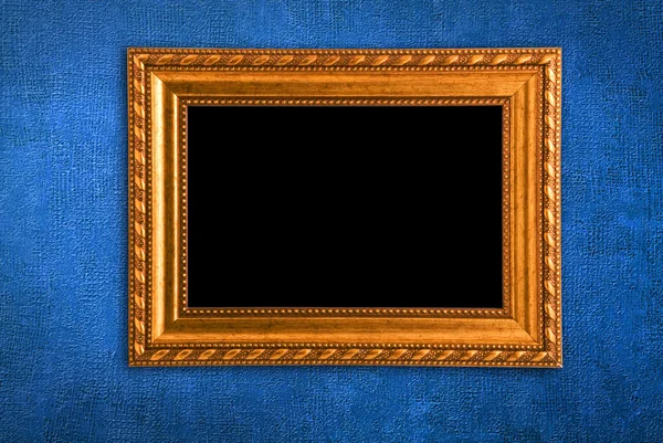 Gouden frame op een blauwe muur achtergrond — Stockfoto