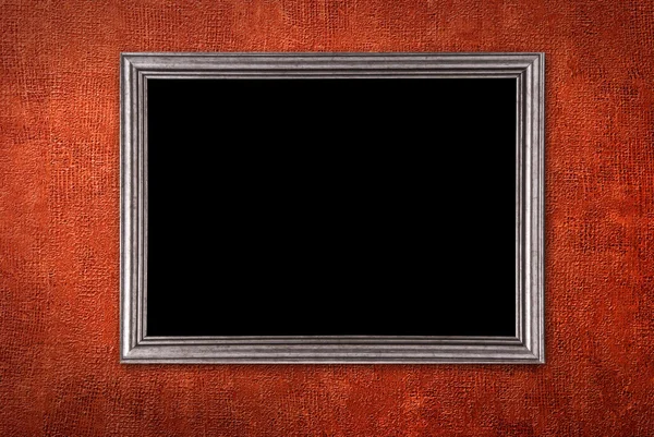Серебряная рамка на фоне красной стены — стоковое фото