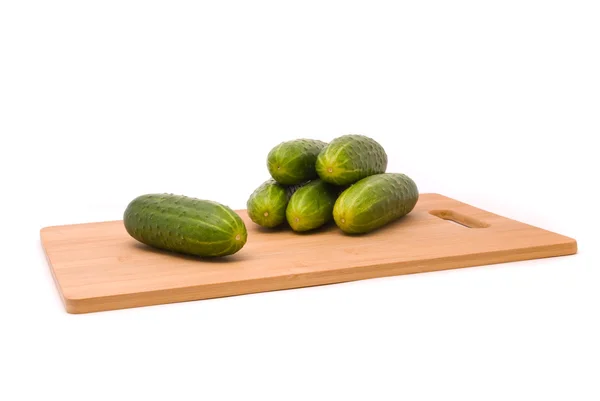 Färska gurkor på en hackbräda — Stockfoto