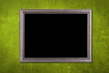 Silver frame on a green wall background clipart