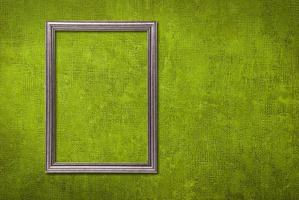 Moldura de prata em um fundo de parede verde — Fotografia de Stock