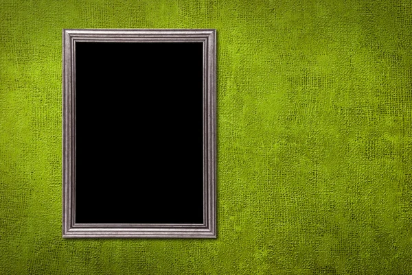 Серебряная рамка на фоне зеленой стены — стоковое фото