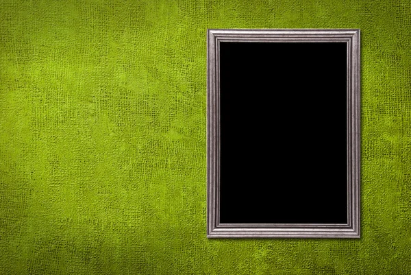 Stříbrný rámeček na pozadí zelené zdi — Stock fotografie