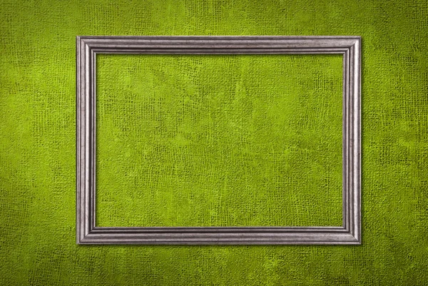 Srebrna ramka na tle zielony ściana — Zdjęcie stockowe