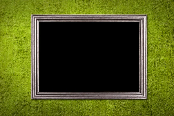 Moldura de prata em um fundo de parede verde — Fotografia de Stock