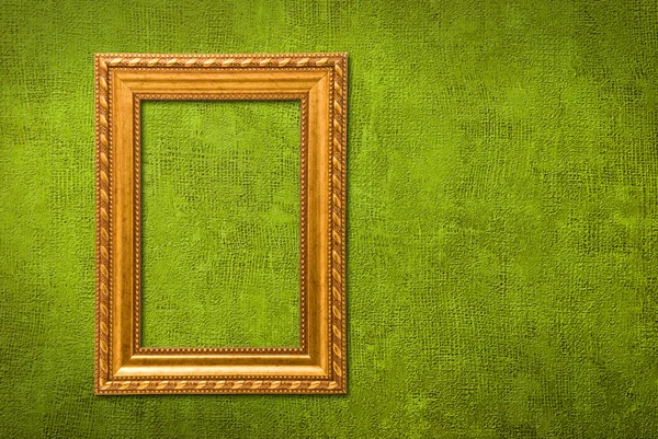 Guld ram på en grön vägg bakgrund — Stockfoto