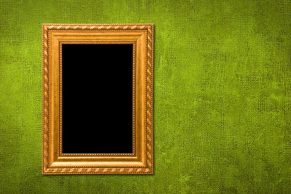 Gold frame on a green wall background — Stock Photo, Image