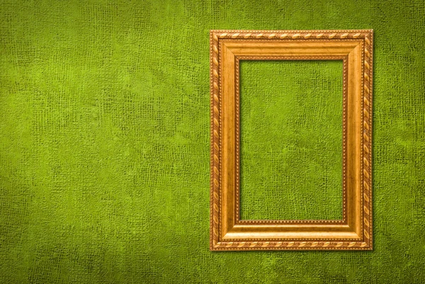 Золотая рамка на фоне зеленой стены — стоковое фото