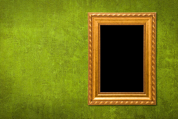 Gold frame on a green wall background