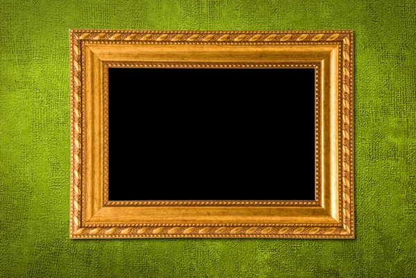Золотая рамка на фоне зеленой стены — стоковое фото