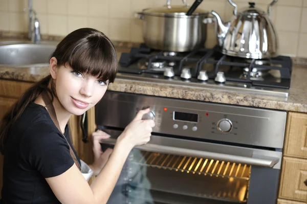 Hermosa ama de casa cambiando el horno — Foto de Stock