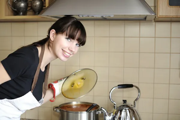 Jeune femme au foyer préparant le repas Image En Vente