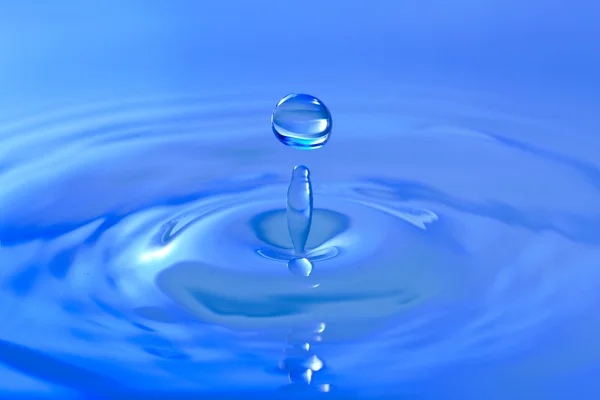 Gota azul espirrando em wa clear limpa — Fotografia de Stock