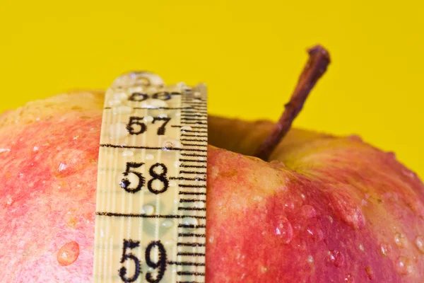 Červené jablko a měřicí páska — Stock fotografie