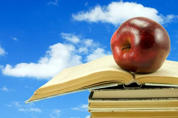 Bookswith apple na pozadí oblohy — Stock fotografie