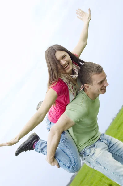 Молодая пара играет на зеленом поле — стоковое фото