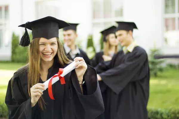 Ein Absolvent mit Diplom und einem Lächeln Stockbild