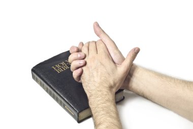 Praying Hands over a Holy Bible clipart