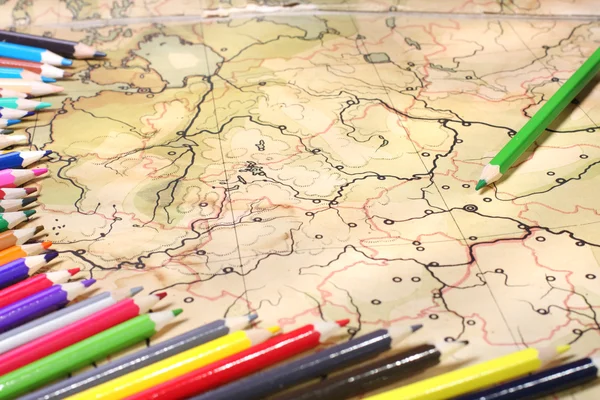 Color pencils on old map — Stock Photo, Image