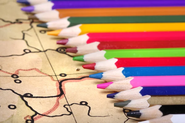 Цветные карандаши на старой карте — стоковое фото