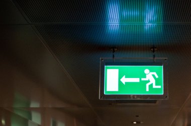 Illuminated green emergency exit sign clipart