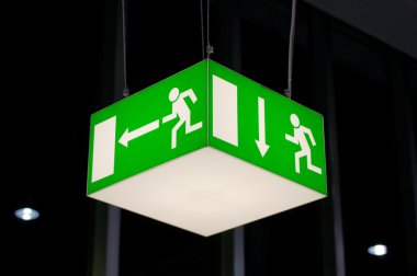 Illuminated green emergency exit sign clipart