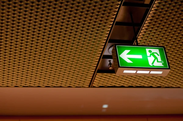 Belyst grön emergency exit tecken — Stockfoto