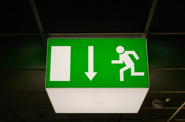 Belyst grön emergency exit tecken — Stockfoto