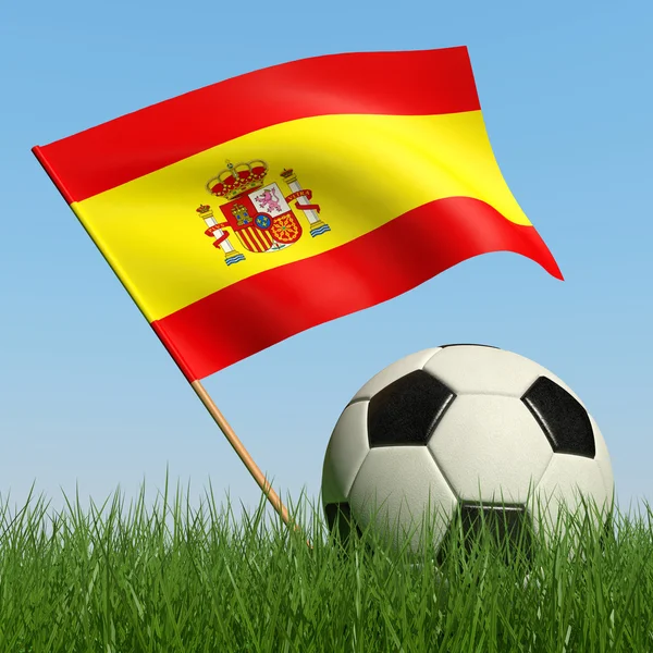 Fotbalový míč v trávě a španělská vlajka. — Stock fotografie