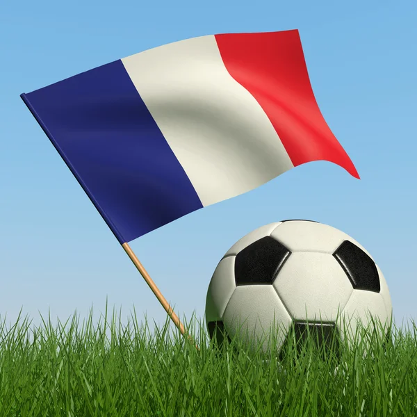 Ballon de football dans l'herbe et le drapeau de la France . — Photo