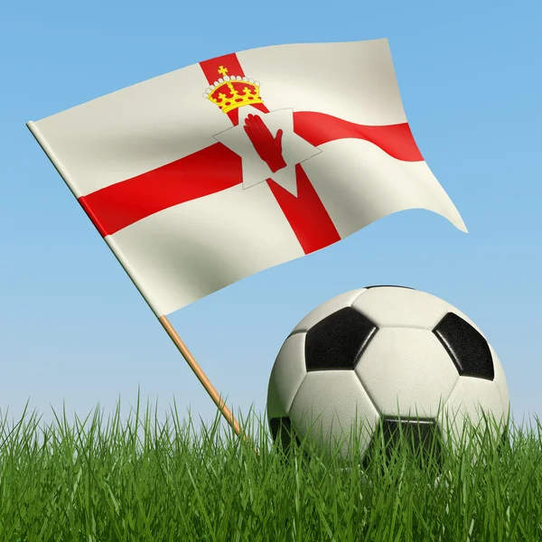 Ballon de football dans l'herbe et le drapeau de l'Irlande du Nord . — Photo
