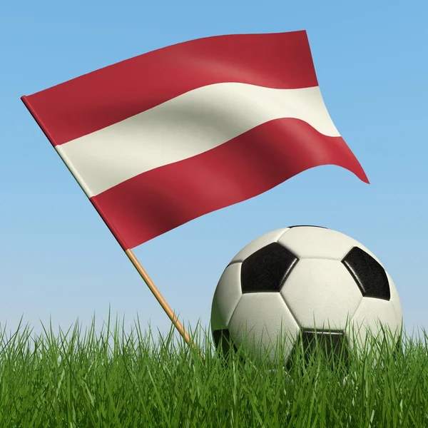 草とラトビアの旗の青い空を背景にサッカー ボール — ストック写真