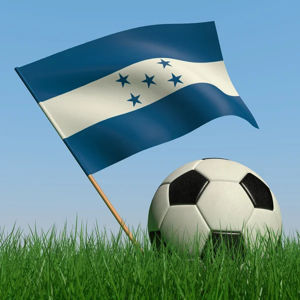 Bola de futebol na grama e a bandeira de Honduras — Fotografia de Stock