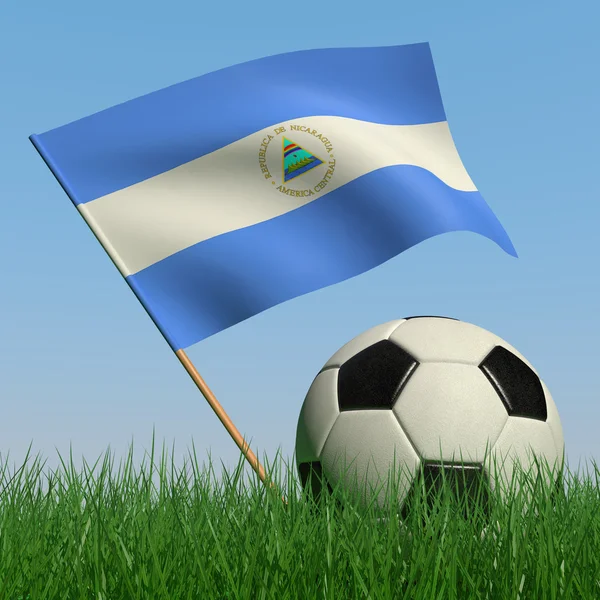 Bola de futebol na grama e a bandeira da Nicarágua — Fotografia de Stock