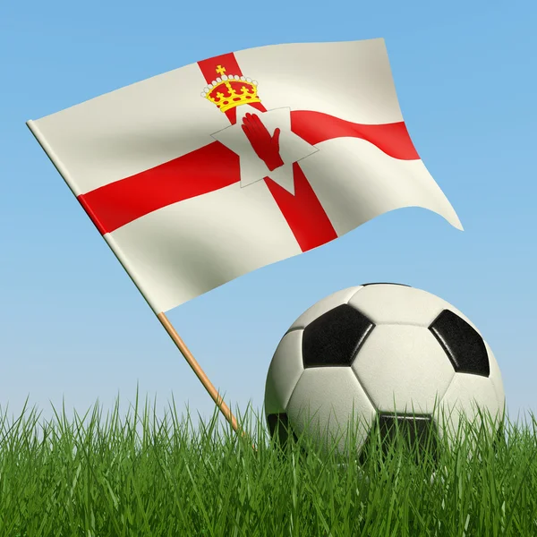 Fußball im Gras und Flagge von Nordirland. — Stockfoto