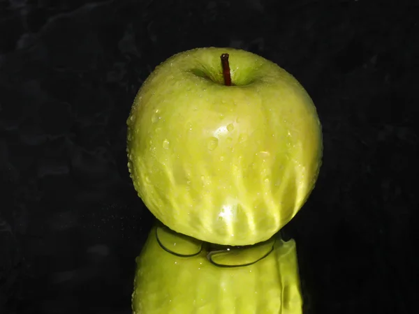 Green apple on black abstract background — Stock Photo, Image