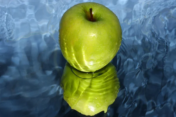 Green apple on water — Stock Photo, Image
