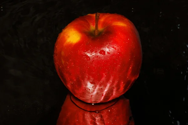 Red apple on black abstract background — Stock Photo, Image