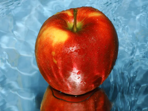 Red apple on water — Stok fotoğraf
