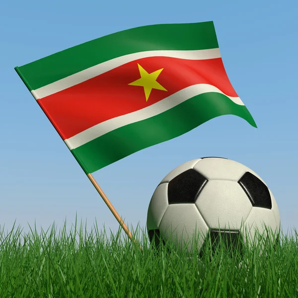 Bola de futebol na grama e a bandeira do Suriname — Fotografia de Stock