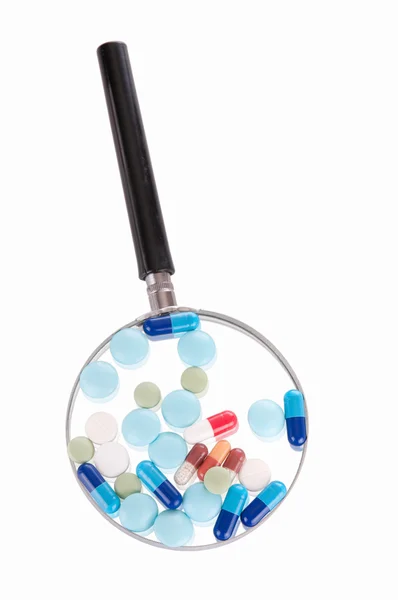 Pills on magnifying glass — Stock Photo, Image