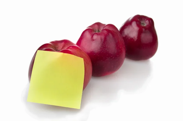 Три красных яблока со стикером — стоковое фото