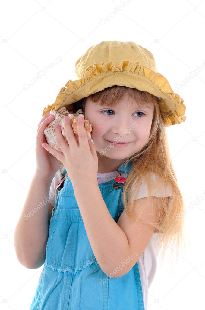 Small girl listens a sea shell