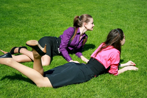 Молодые деловые женщины отдыхают на траве — стоковое фото