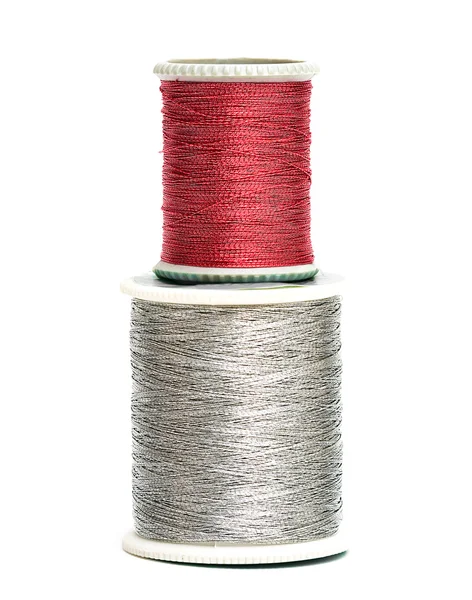 Czerwone i srebrne szpule nici — Zdjęcie stockowe