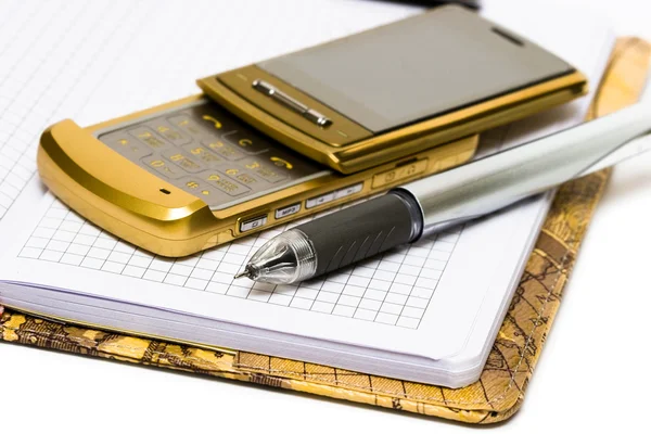 Telefone celular com caneta e notebook — Fotografia de Stock